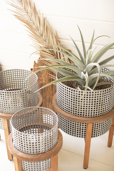 SET OF THREE WOVEN METAL PLANTERS WITH WOOD STANDS